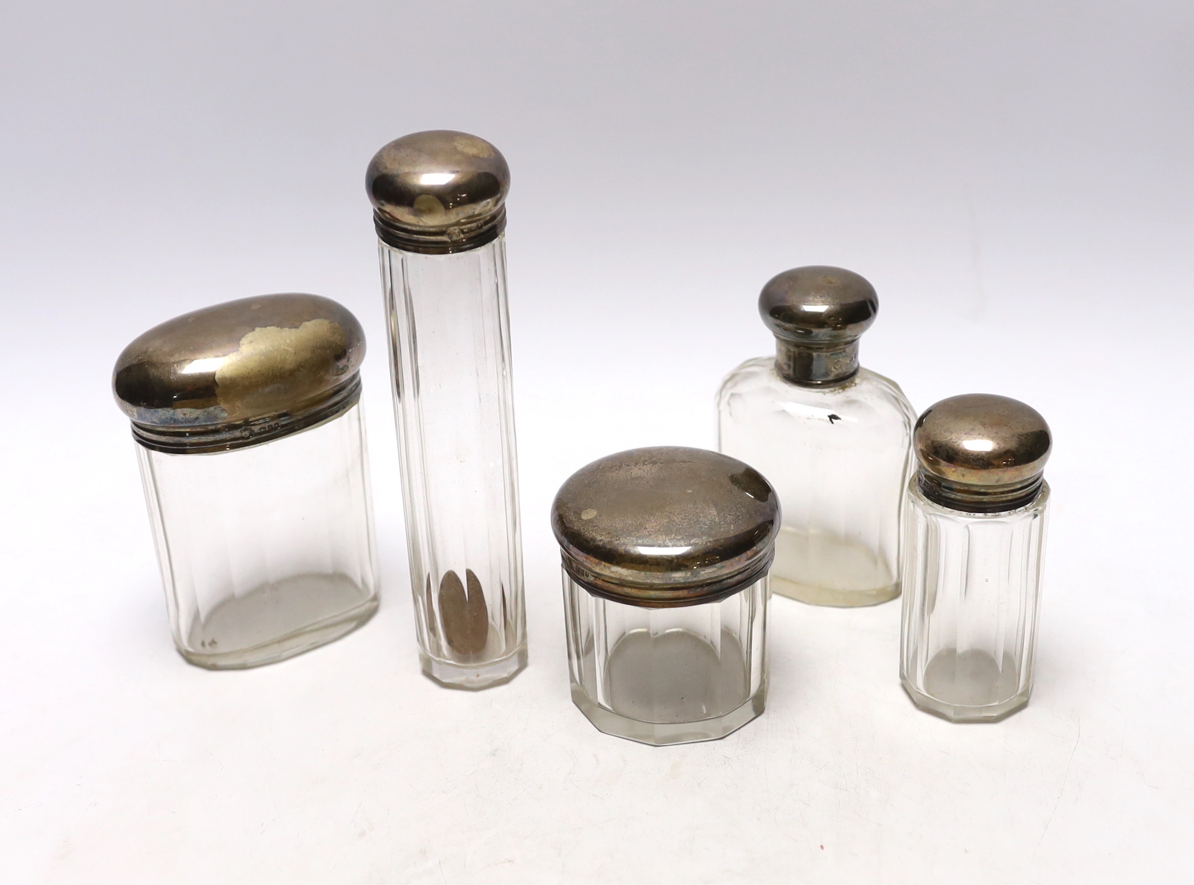 Five assorted silver topped toilet jars, London, 1911/12, largest 16.5cm.